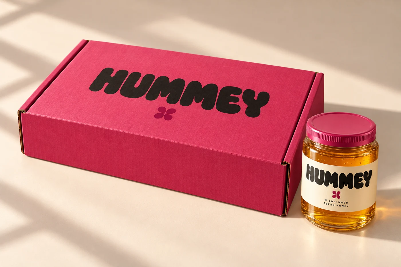 Closed raspberry HUMMEY trio shipper beside a three-quarter Wildflower jar